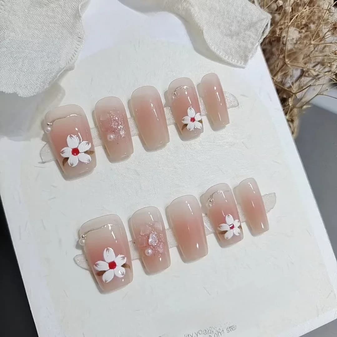 Kratke umjetne nokte oblika lijesa, ružičaste s dizajnom magnolije